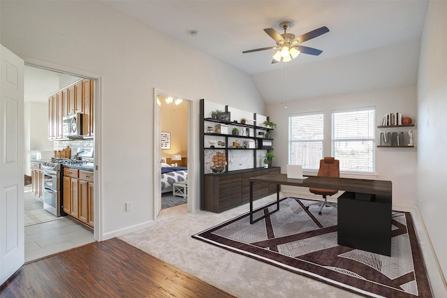 office with vaulted ceiling, a ceiling fan, light wood-type flooring, and baseboards