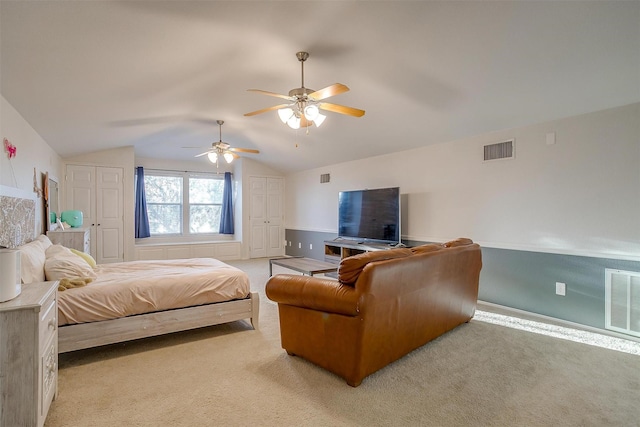 bedroom with lofted ceiling, multiple closets, visible vents, and light carpet