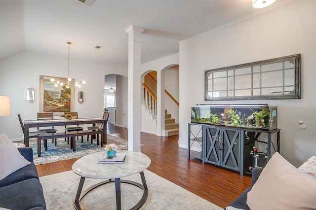 living room with stairway, wood finished floors, visible vents, baseboards, and arched walkways