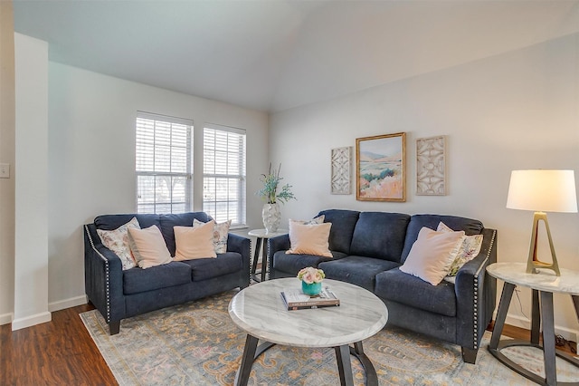 living area featuring lofted ceiling, wood finished floors, and baseboards