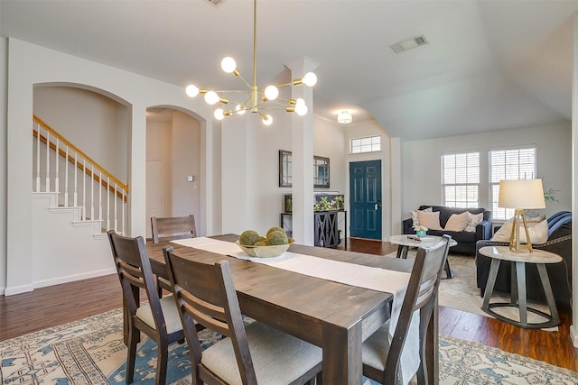 dining room with visible vents, stairs, dark wood-type flooring, and an inviting chandelier