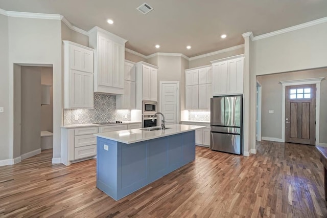 kitchen featuring stainless steel appliances, a sink, visible vents, white cabinets, and light countertops