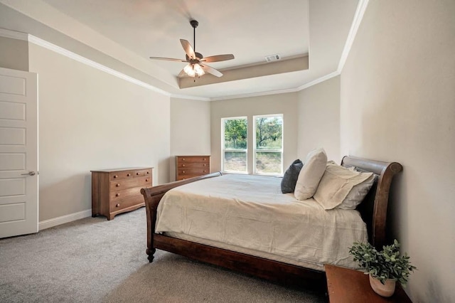 bedroom with carpet floors, ornamental molding, a raised ceiling, and visible vents