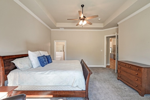 carpeted bedroom with connected bathroom, a ceiling fan, baseboards, ornamental molding, and a raised ceiling