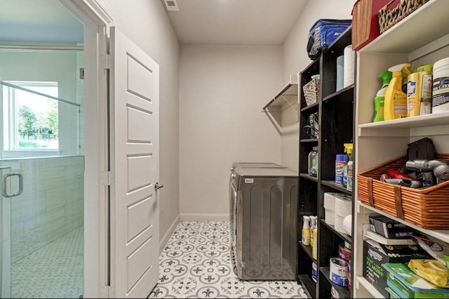 laundry room with light tile patterned floors, visible vents, baseboards, and laundry area