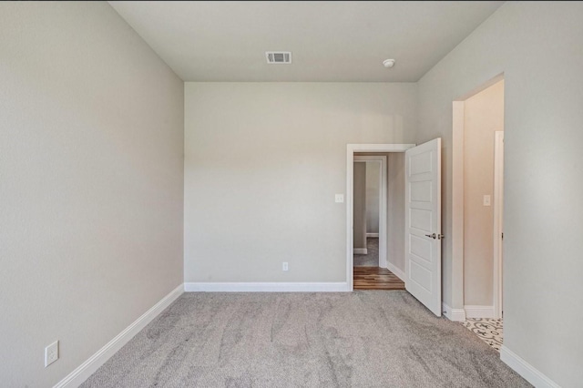 carpeted spare room with baseboards and visible vents