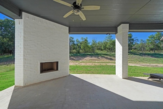 view of patio featuring an outdoor brick fireplace and a ceiling fan