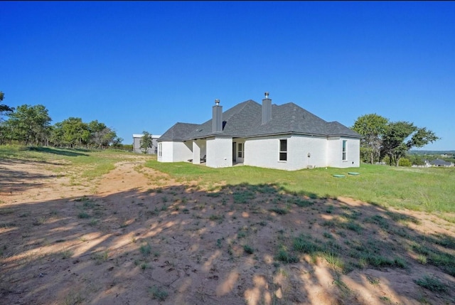 back of property featuring a yard and a chimney