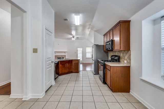 kitchen featuring light tile patterned flooring, visible vents, light countertops, backsplash, and black appliances