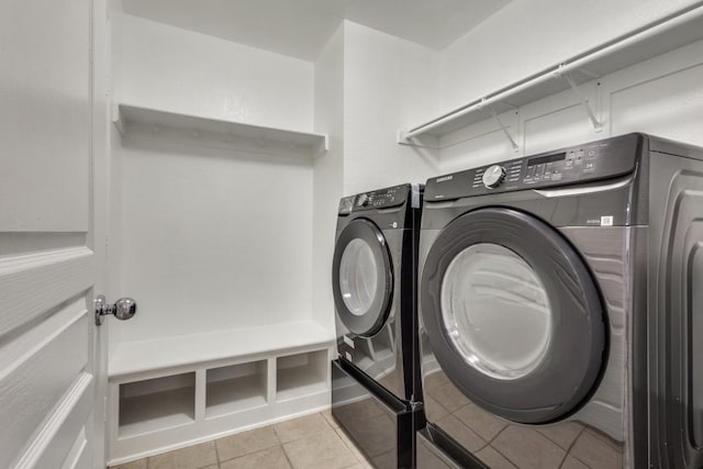 laundry room with laundry area, independent washer and dryer, and light tile patterned flooring