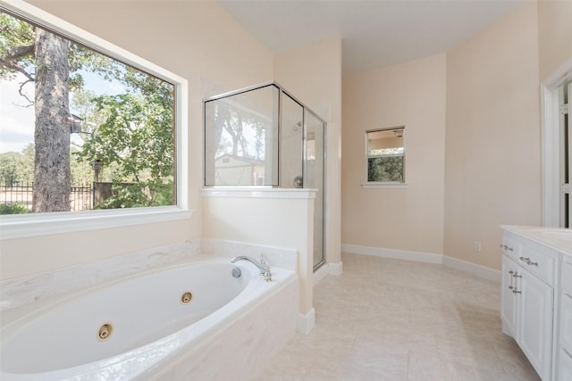 bathroom featuring baseboards, a jetted tub, vanity, and a stall shower