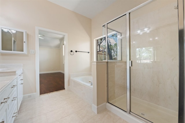 bathroom featuring a garden tub, a stall shower, vanity, tile patterned flooring, and baseboards