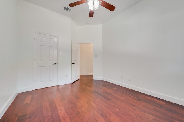 unfurnished bedroom featuring a ceiling fan, visible vents, baseboards, and wood finished floors