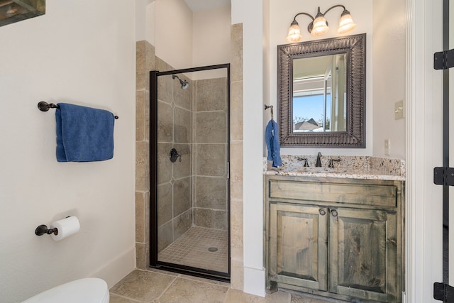 bathroom with toilet, vanity, and a stall shower