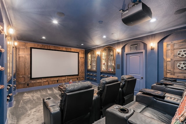 home theater with a textured ceiling, ornamental molding, recessed lighting, carpet floors, and wooden walls
