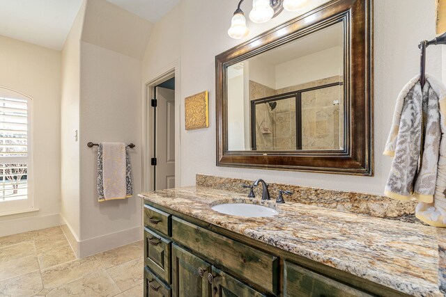 full bath featuring a wealth of natural light, a stall shower, baseboards, and vanity