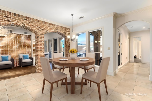 dining room with crown molding, arched walkways, visible vents, a chandelier, and brick wall