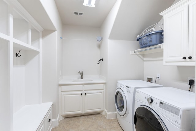 clothes washing area with cabinet space, visible vents, independent washer and dryer, and a sink