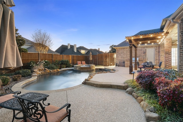 view of pool featuring a patio, a fenced backyard, and a pool with connected hot tub