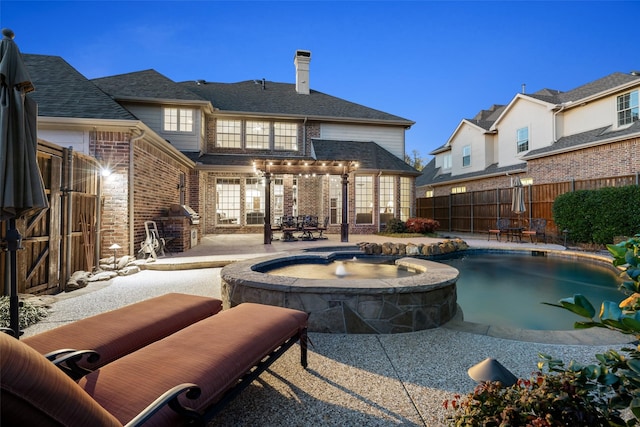 view of pool featuring a patio, a fenced backyard, a pool with connected hot tub, and a grill