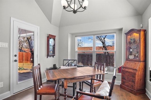 dining space with vaulted ceiling, a healthy amount of sunlight, wood finished floors, and a notable chandelier