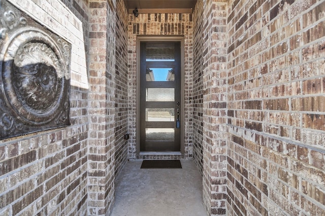 view of exterior entry featuring brick siding