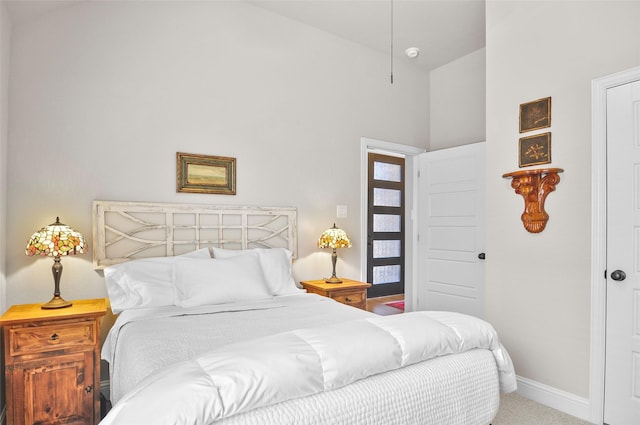 carpeted bedroom with baseboards and vaulted ceiling