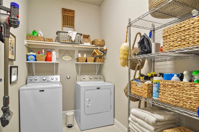 laundry room with laundry area, tile patterned flooring, baseboards, and washing machine and clothes dryer