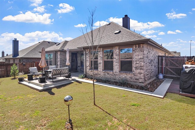 rear view of house with a lawn, a patio, a fenced backyard, an outdoor hangout area, and brick siding