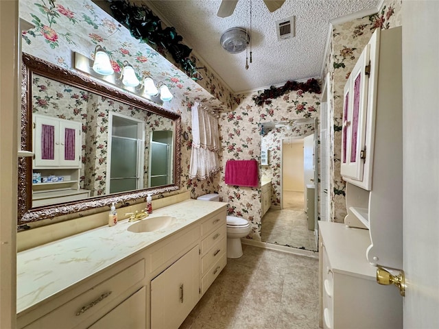 full bathroom featuring wallpapered walls, a stall shower, visible vents, a textured ceiling, and vanity