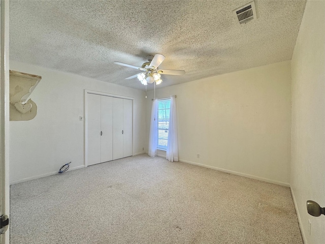 unfurnished bedroom with baseboards, visible vents, a ceiling fan, carpet floors, and a closet