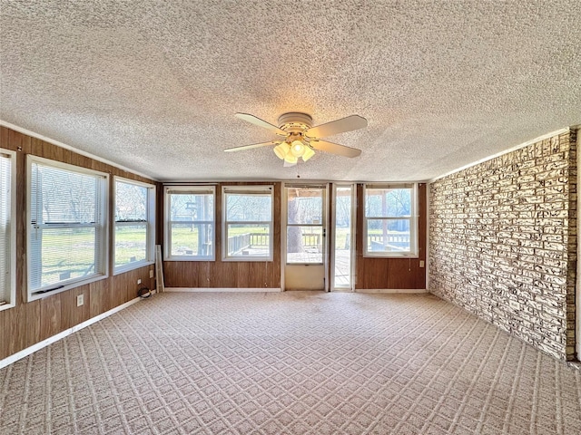 unfurnished sunroom featuring a ceiling fan