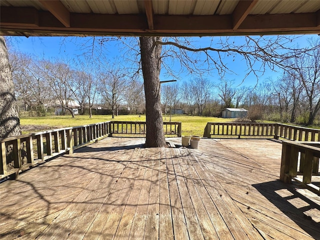 deck featuring an outbuilding, a yard, and a shed