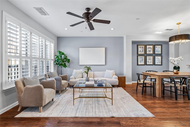 living room with recessed lighting, visible vents, baseboards, and wood finished floors