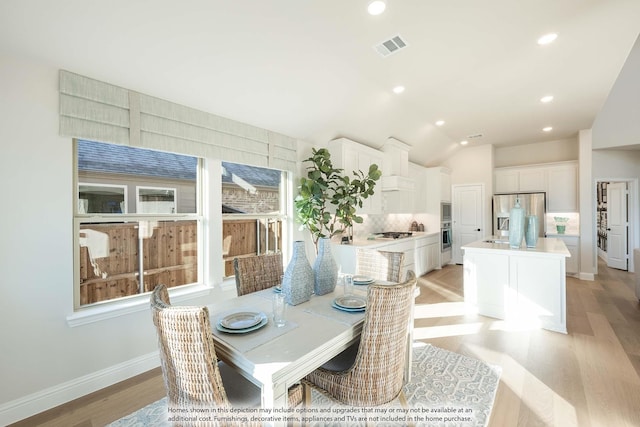 dining room with lofted ceiling, recessed lighting, visible vents, baseboards, and light wood finished floors