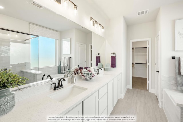 bathroom featuring a sink, visible vents, and a shower stall