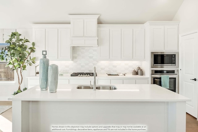 kitchen with decorative backsplash, oven, built in microwave, light countertops, and a sink