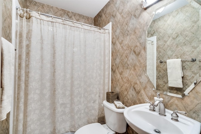 bathroom featuring toilet, tile walls, a sink, and a shower with shower curtain