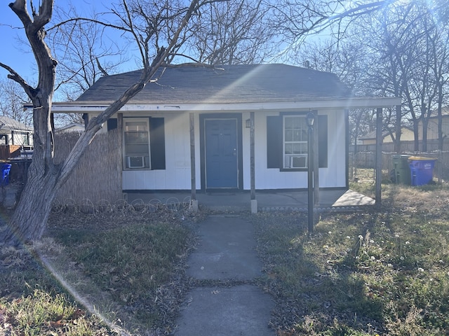 bungalow with a porch, a shingled roof, and fence