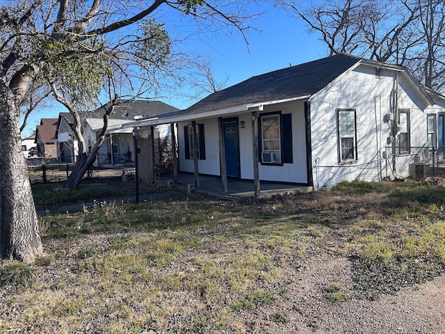 view of front facade featuring a porch, cooling unit, and fence