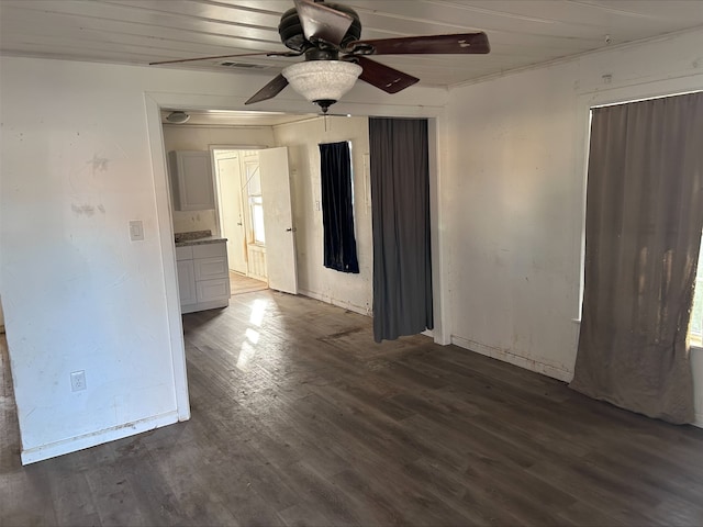 spare room featuring a ceiling fan and dark wood-style flooring