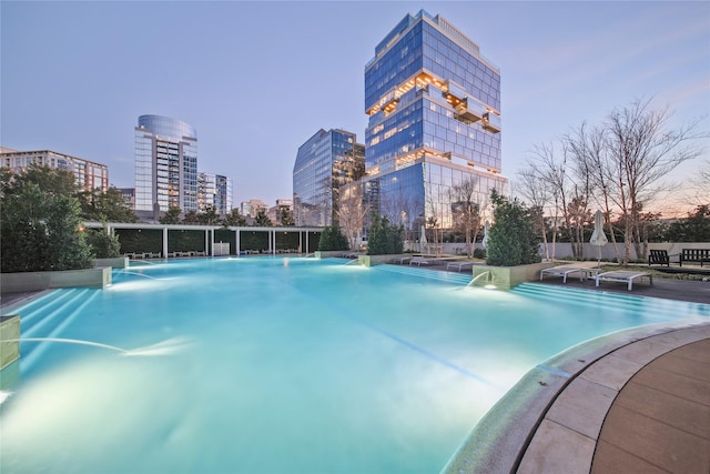 pool at dusk with a view of city and fence