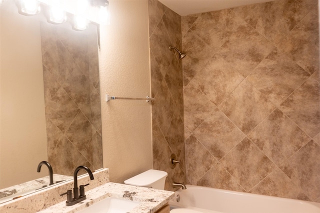 bathroom with tub / shower combination, vanity, and toilet