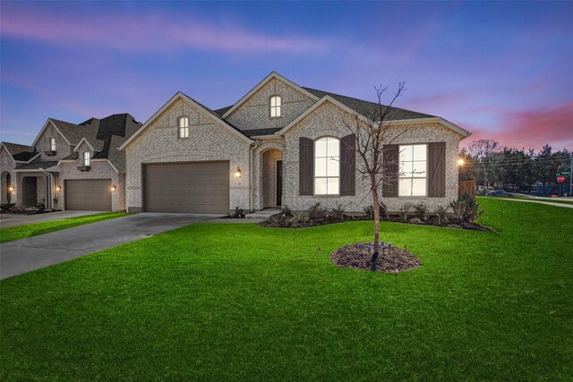 4212 Savannah Ct, Denison, TX 75020 - french country style house featuring a front lawn, driveway, brick siding, and a garage