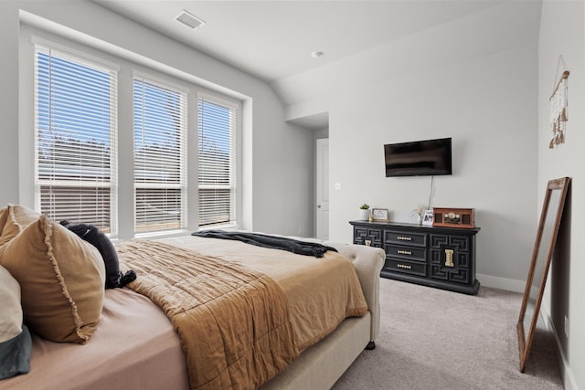 carpeted bedroom with visible vents, baseboards, and vaulted ceiling