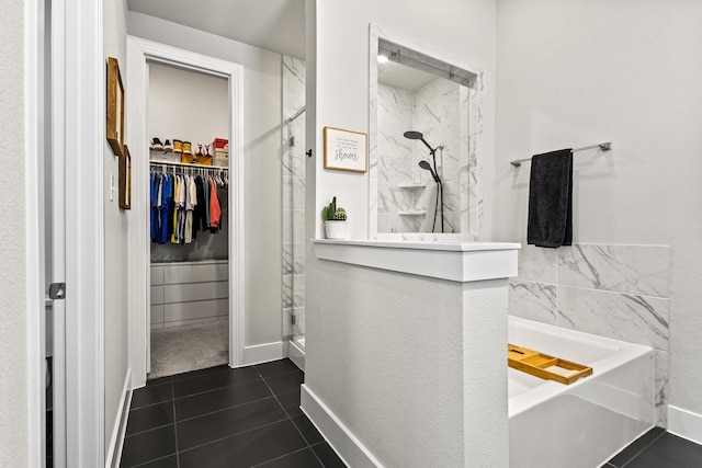 bathroom with a garden tub, tile patterned floors, a spacious closet, baseboards, and walk in shower