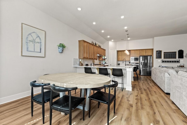 dining space with light wood-type flooring, baseboards, and recessed lighting