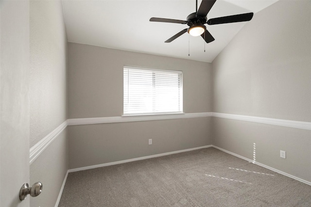 carpeted spare room featuring a ceiling fan, lofted ceiling, and baseboards