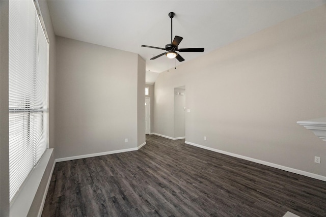 empty room featuring dark wood-style floors, baseboards, vaulted ceiling, and a ceiling fan