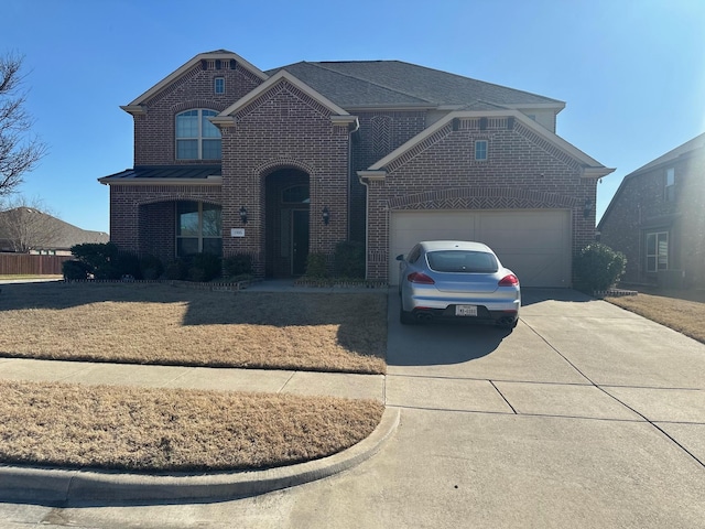 view of front facade with metal roof, concrete driveway, brick siding, and an attached garage